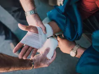 hand being wrapped with gauze in a first aid course